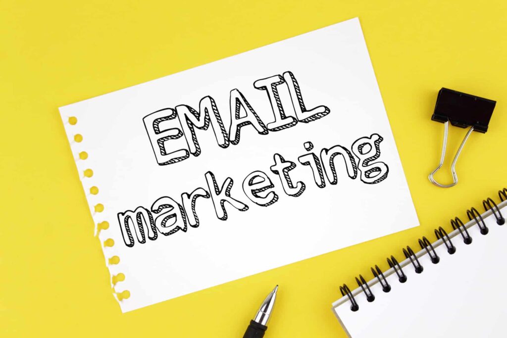 A blank paper featuring the inscription "Email Marketing" sits on a wooden desk. This image reflects themes relevant to web design services, digital marketing agency, and SEO optimization.