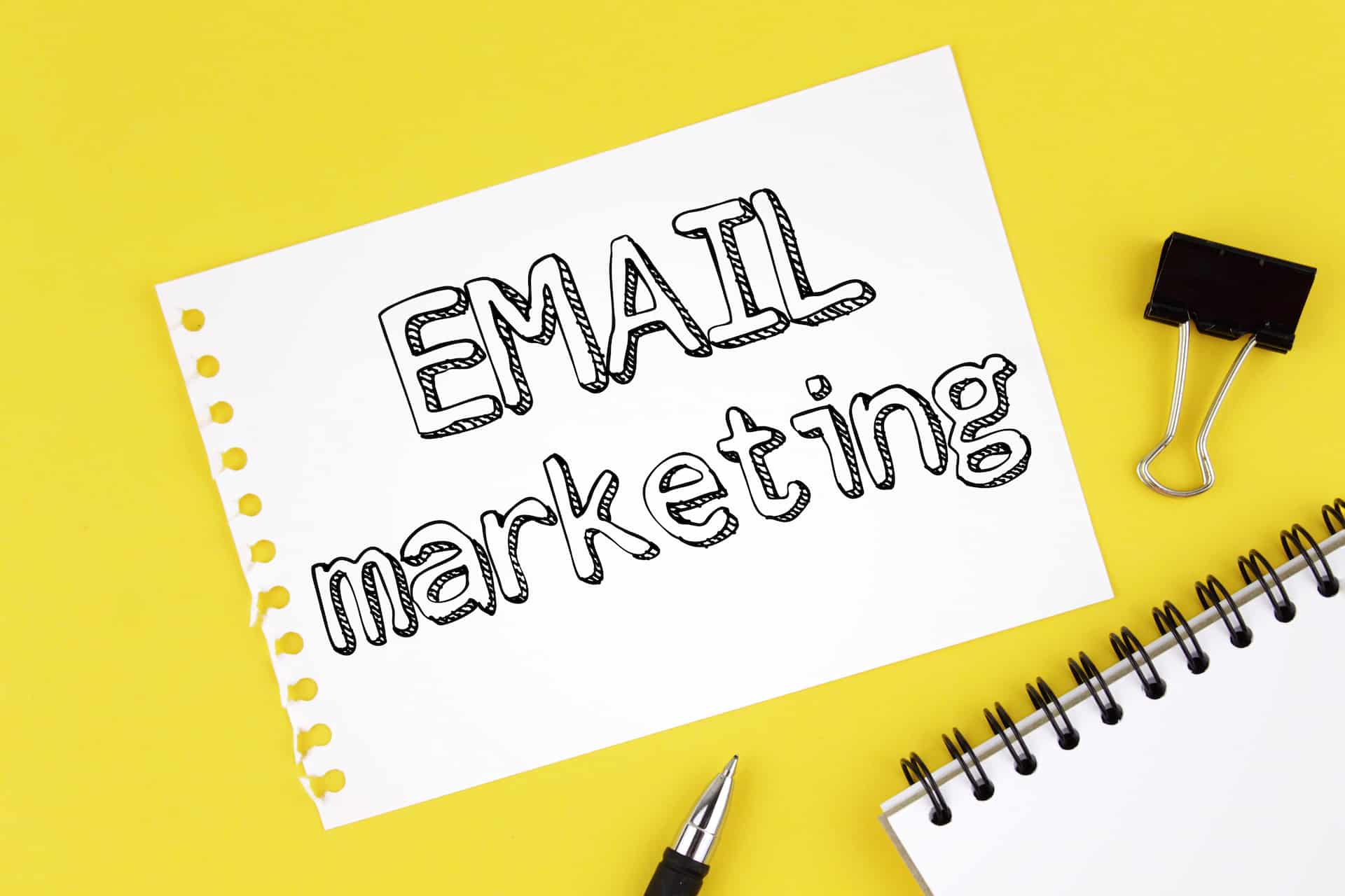 A blank paper featuring the inscription "Email Marketing" sits on a wooden desk. This image reflects themes relevant to web design services, digital marketing agency, and SEO optimization.